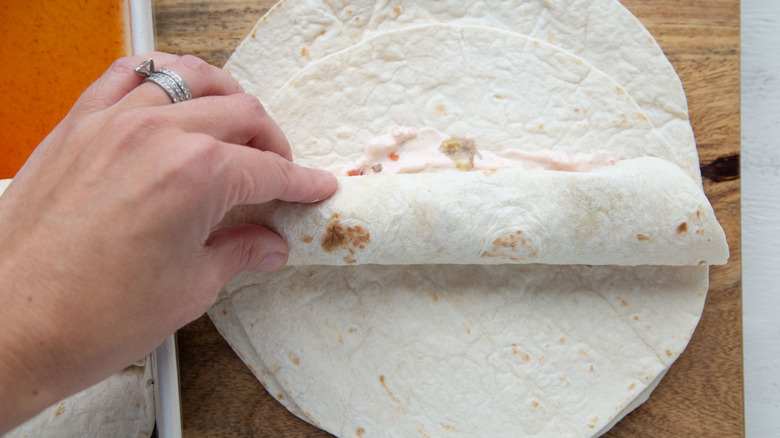 hand rolling tortilla