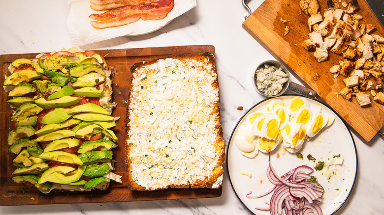 Layering focaccia with avocado