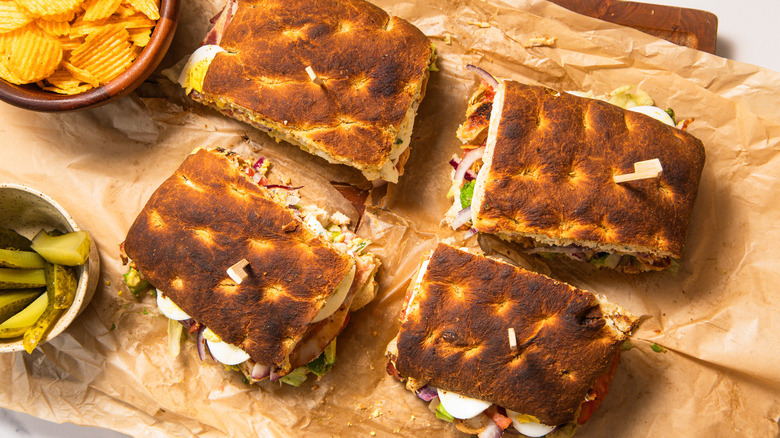 Four loaded Cobb sandwiches on parchment paper