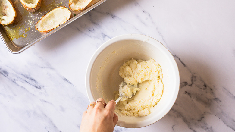 Mixing potato filling in bowl.