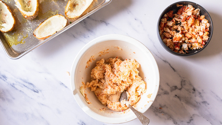 Adding lobster to potato filling in bowl.