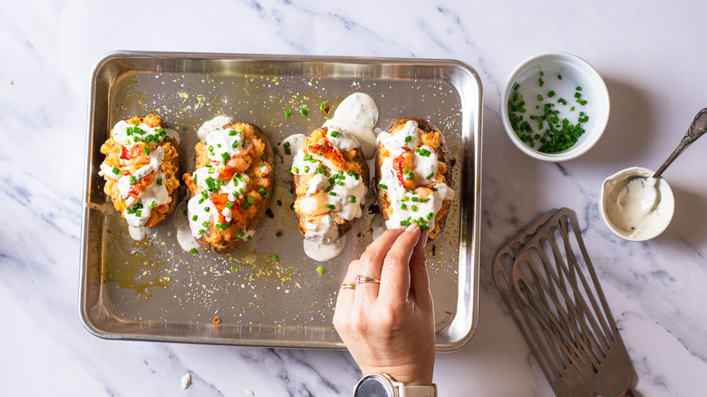 Topping potatoes stuffed with lobster potato filling with cream sauce.