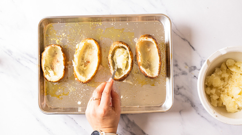 Scooping out potato flesh.