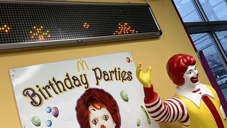 Ronald McDonald statue and sign inside McDonald's