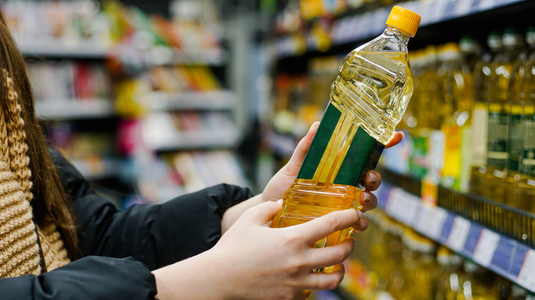 Foodie holding bottle of cooking oil in a grocery store