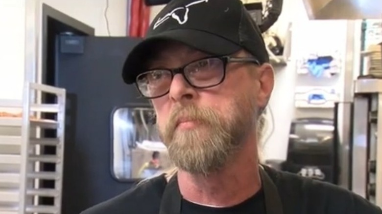 LongHorn Steakhouse Grill Master Legend Tony Behrens in a black shirt, glasses, and hat