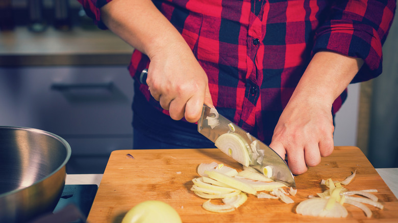 A cook preparing onoins.
