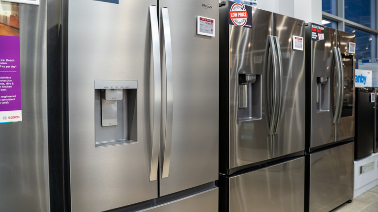 Stainless-steel fridges lined up in a store showroom