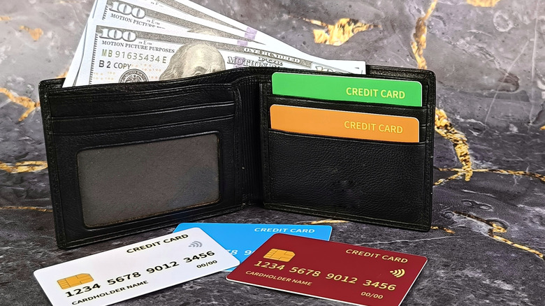 Wallet with hundred-dollar bills and credit cards on a countertop