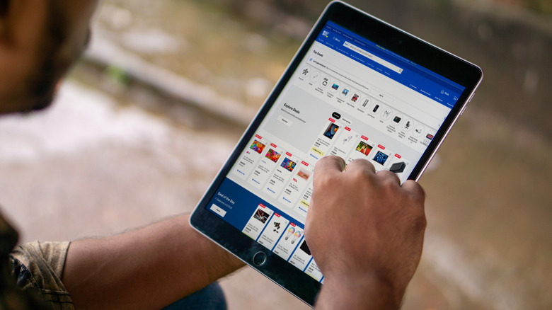 Person using a tablet to browse the Best Buy website