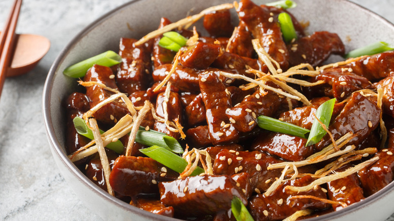 Beef ginger with tender strips of flank steak in a sauce in a bowl