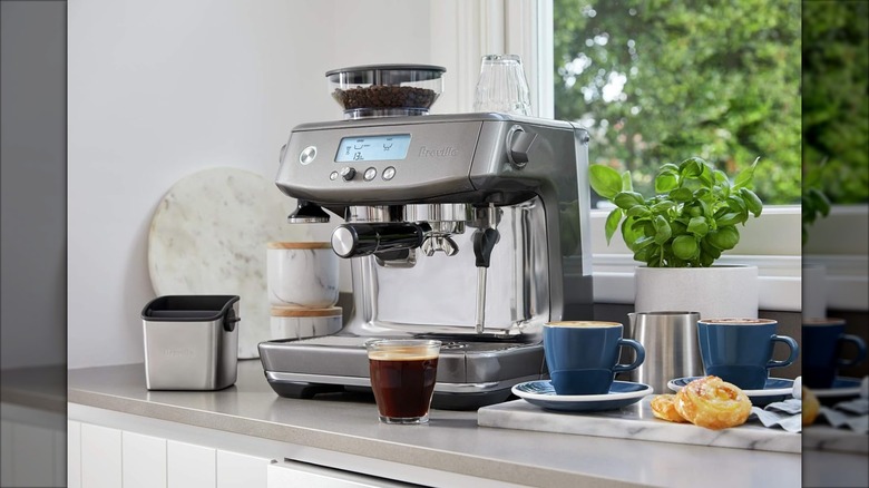 Breville Barista Pro surrounded by drinks and food on a countertop