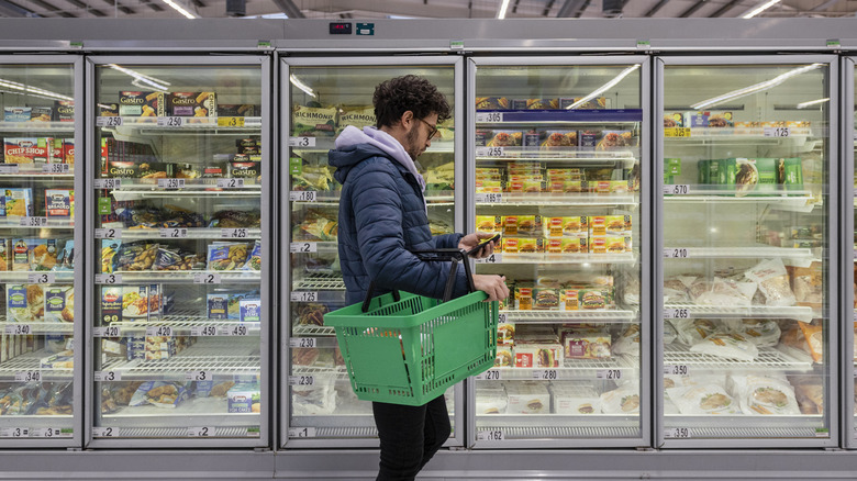Man shopping in a supermarket while on a budget