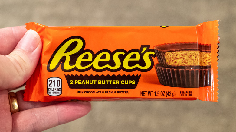 Person holding packet containing Reese's Peanut Butter Cups in 2025