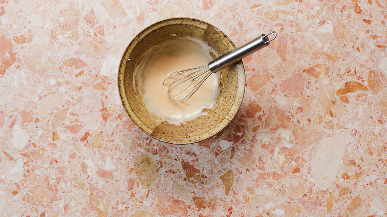 Mayonnaise mixture in bowl with whisk