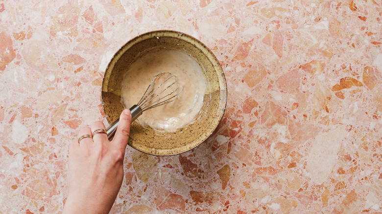 Whisking sesame seeds into sauce