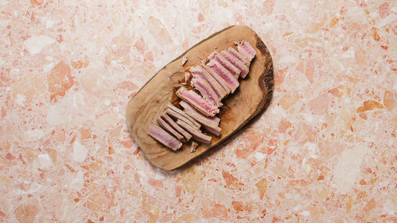 Sliced tuna steaks on cutting board