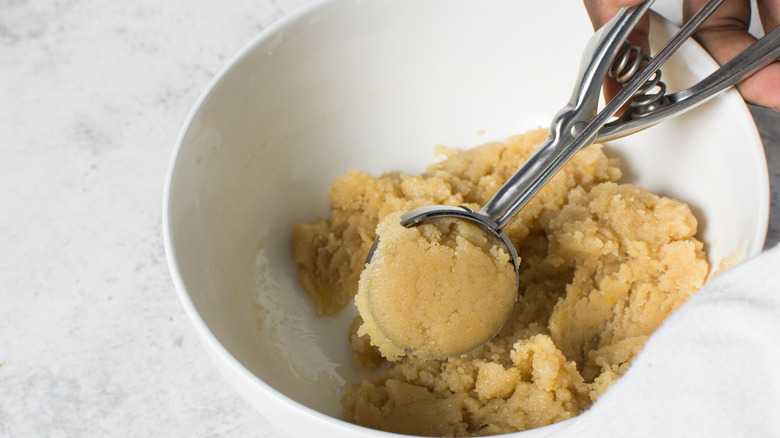 scooping cookie dough in bowl