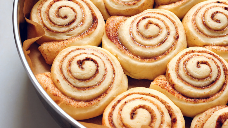 raw cinnamon rolls in a circular pan