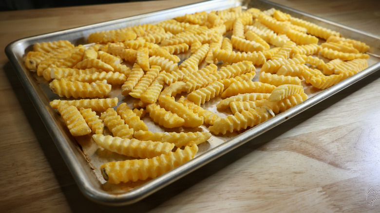 frozen crinkle cut fries on a sheet pan