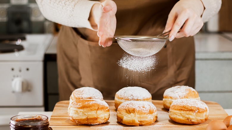 woman with powdered sugar donuts