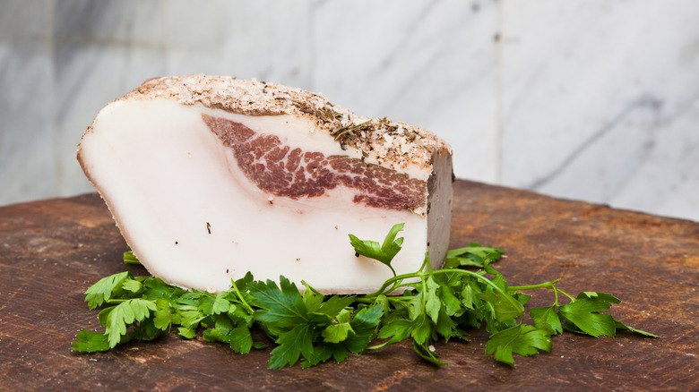 A large piece of fat rests on top of parsley