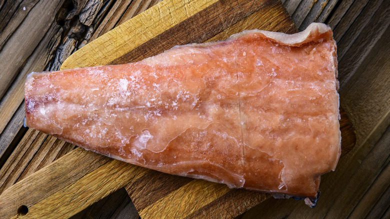 frozen salmon on cutting board