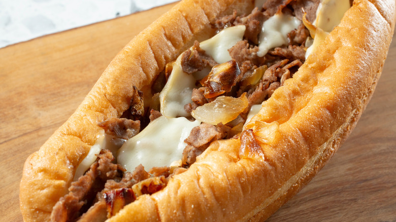 Close up of a cheesesteak on wooden surface
