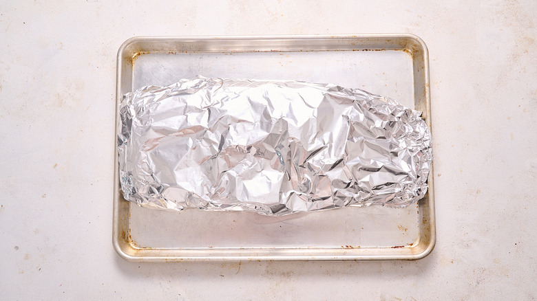aerial view of ribs wrapped in foil on a baking sheet