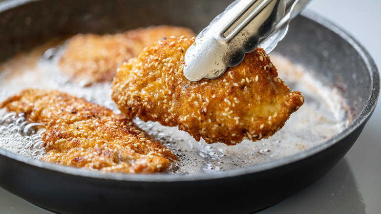 chicken cutlets frying in pan