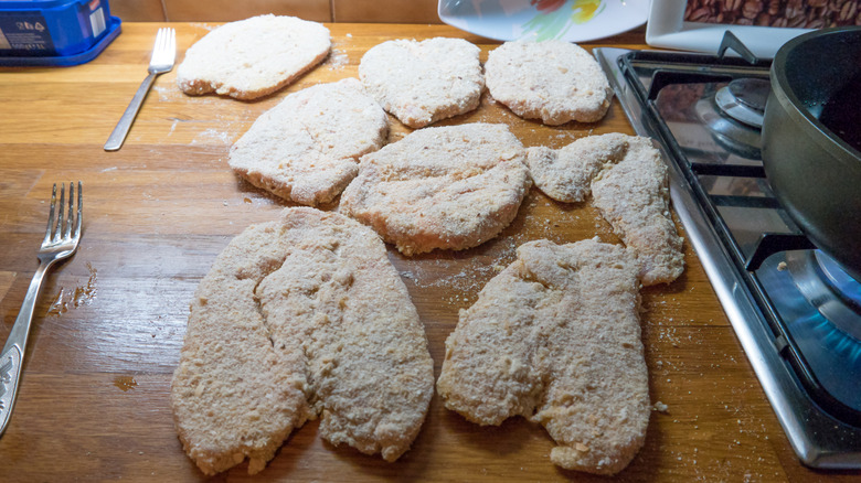 Butterflied and breaded chicken on table
