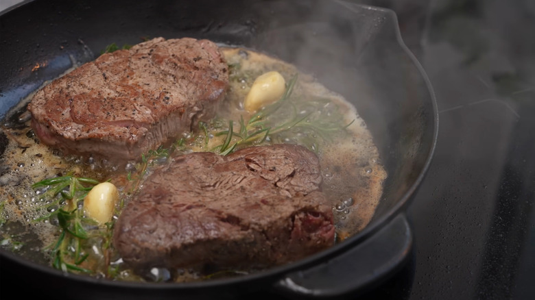 Juicy steak sizzling with butter and garlic