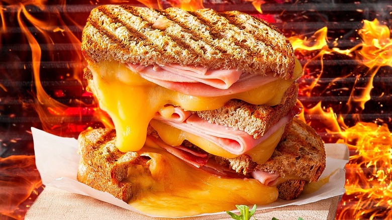 A grilled cheese sandwich with grill grates and flames in the background