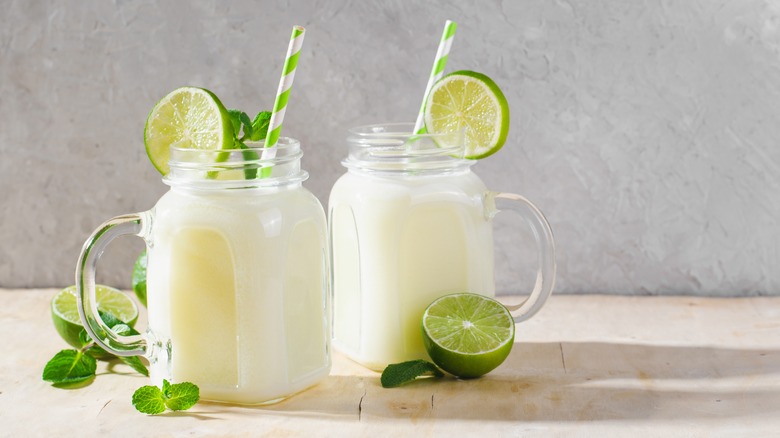 two mason jar glasses filled with limeade