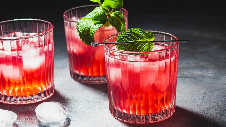 Three cranberry cocktails garnished with mint leaves
