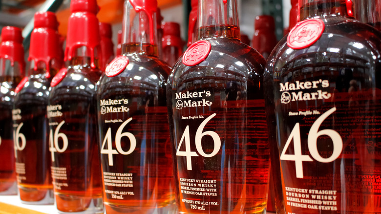 a line of bottles of Maker's Mark 46 on a liquor store shelf