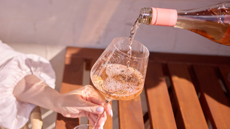 Rosé being poured from bottle into wine glass