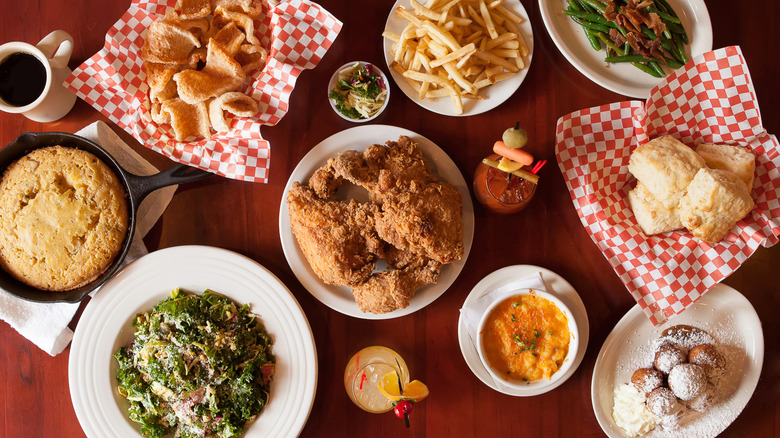 a plate of fried chicken surrounded by many different Southern side dishes