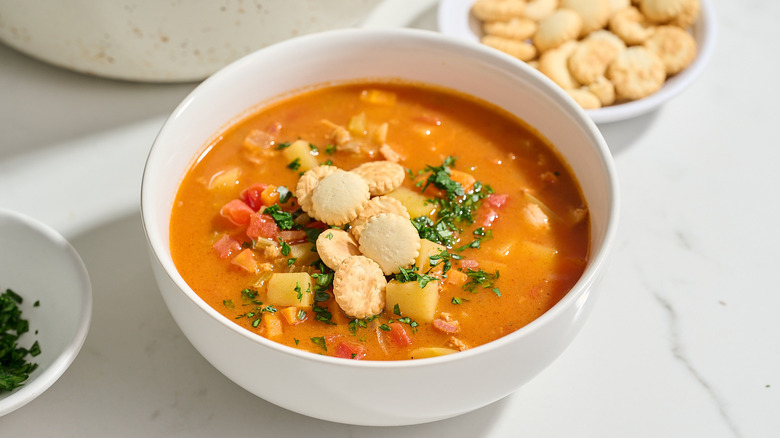 bowl of soup on table with parsley and crackers