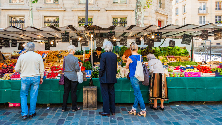 people shopping at market in French city