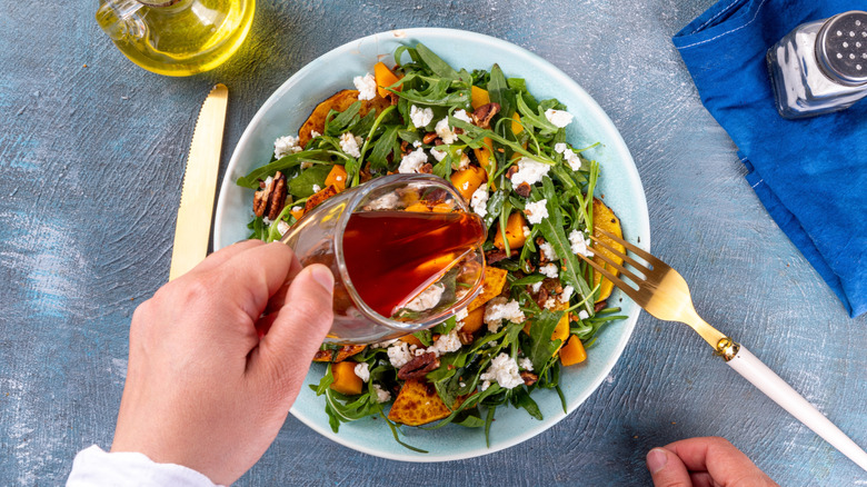 fall salad with pumpkin feta walnuts and rugola and maple syrup and oil alongside
