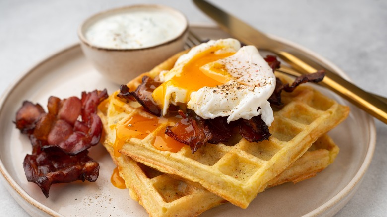 Poached egg with bacon and waffles