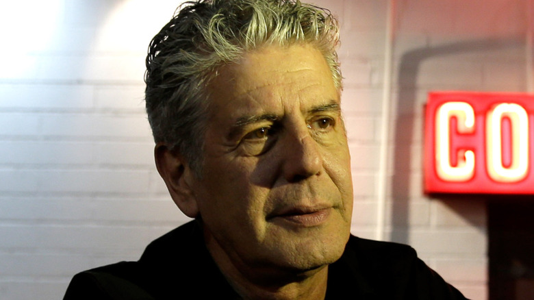 Anthony Bourdain standing outside a cocktail bar