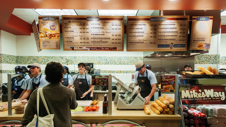 Workers prepare sandwiches at a Jersey Mike's Subs fast casual restaurant