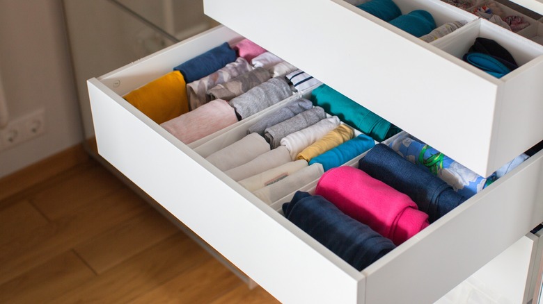 Folded textiles stored vertically in drawers