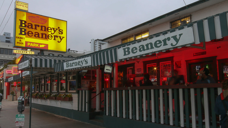 The exterior of Barney's Beanery bar and restaurant in West Hollywood, Los Angeles, has an illuminated sign out front.