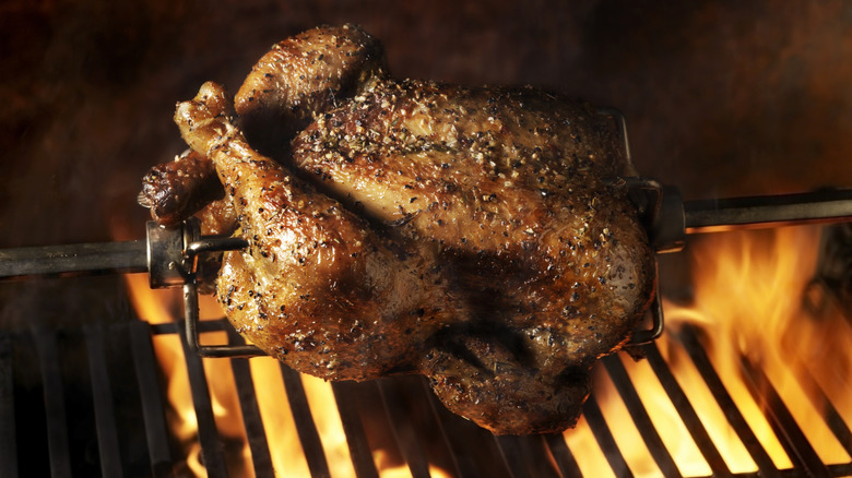 whole turkey on the grill over flames