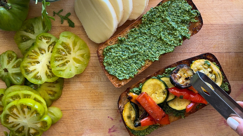 adding veggies to bread