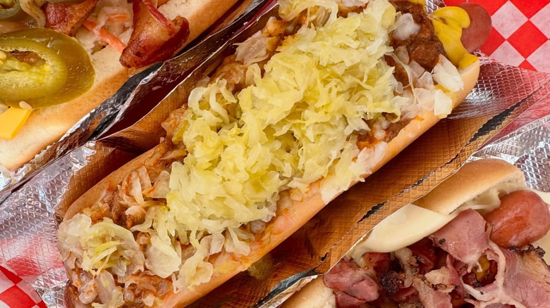 Pink's hot dogs with different toppings in foil and checkered paper