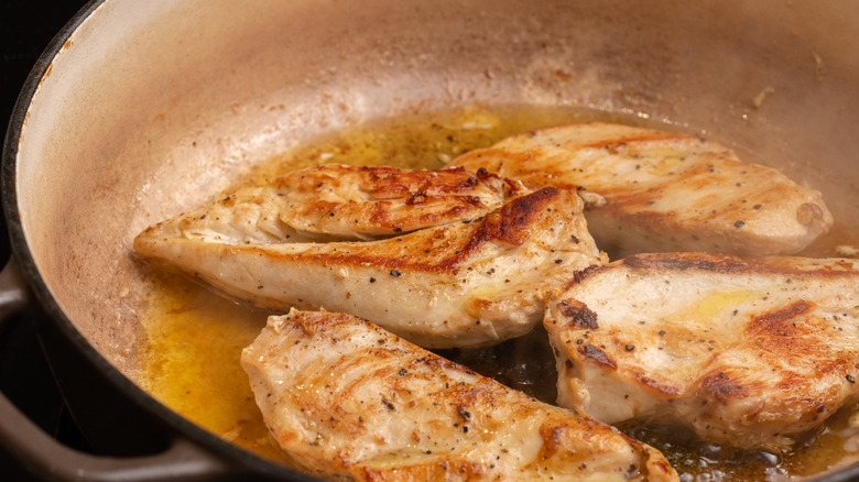 chicken frying in pan